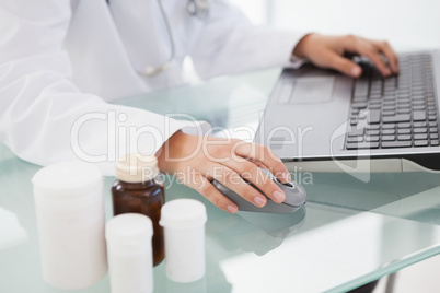 Doctor typing out prescriptions
