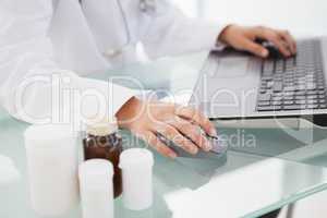 Doctor typing out prescriptions