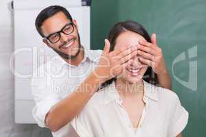 Man covering womans eyes