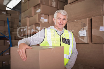 Worker carrying box in warehouse