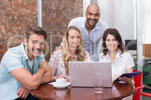 Smiling business team working together with laptop