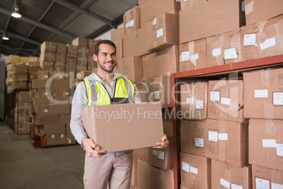 Worker carrying box in warehouse