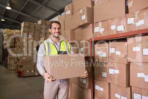 Worker carrying box in warehouse