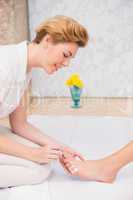 Woman getting a pedicure from beautician