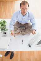 Zen businessman meditating on his desk