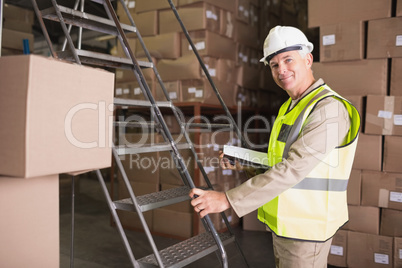 Worker with diary in warehouse