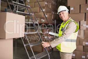 Worker with diary in warehouse