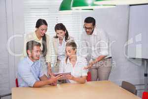 Smiling business people using digital tablet in meeting