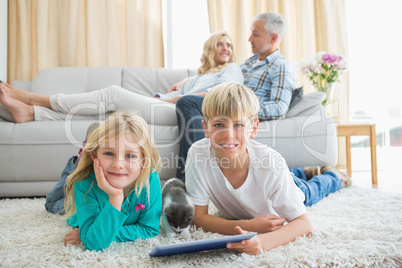 Siblings using tablet pc on the floor