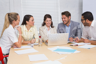 Casual business team having a meeting using laptop