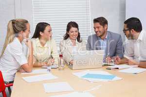 Casual business team having a meeting using laptop