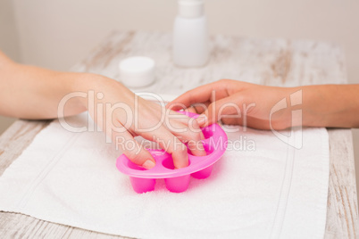 Woman soaking her nails in nail bowls