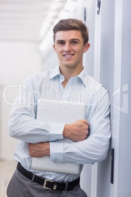 Portrait of a smiling technician holding a laptop