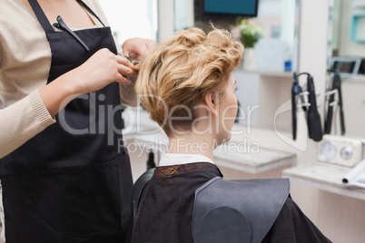 Happy hairdresser cutting a customers hair