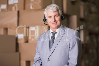 Businessman using headset in warehouse