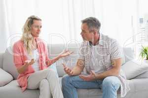 Unhappy couple having an argument on the couch