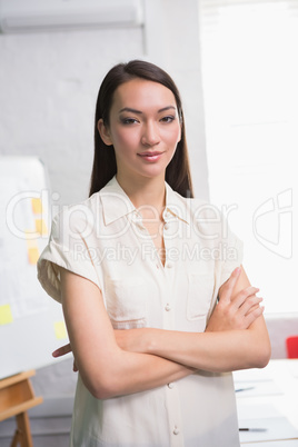 Confident businesswoman with arms crossed in office