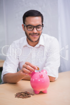 Man putting some coins into piggybank