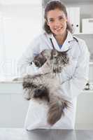 Smiling vet with a maine coon in her arms