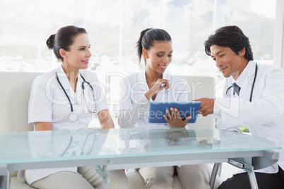 Smiling doctors using a tablet pc Smiling doctors using a tablet pc