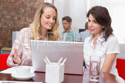 Happy businesswomen looking at computer screen together