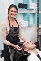 Hair stylist washing mans hair