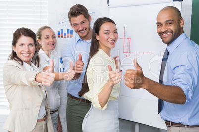 Smiling business team gesturing thumbs up in meeting Smiling business team gesturing thumbs up in meeting