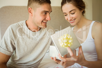 Cute girlfriend opening her gift