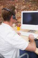 Man with headset typing on laptop