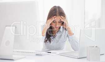 Tired businesswoman sitting at her desk