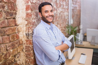 Smiling young businessman with arms crossed