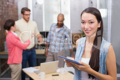 Smiling woman holding tablet in front of her colleague Smiling woman holding tablet in front of her colleague