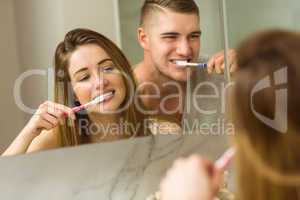 Cute couple brushing their teeth