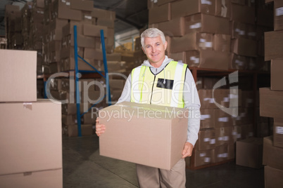 Worker carrying box in warehouse