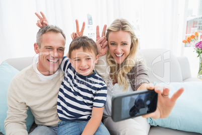 Cheerful family taking self pictures with a smartphone