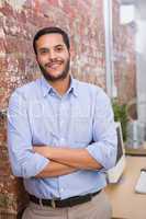 Smiling businessman with arms crossed at office