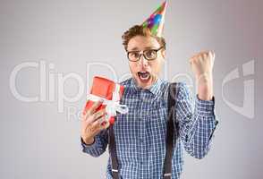 Geeky hipster wearing party hat holding gift