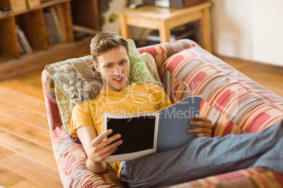 Young man reading magazine on his couch