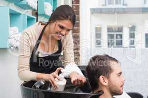 Hair stylist putting conditioner in mans hair