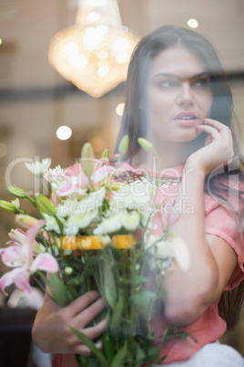 Pretty brunette holding bunch of flowers