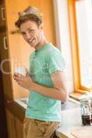 Young man smiling at camera holding coffee