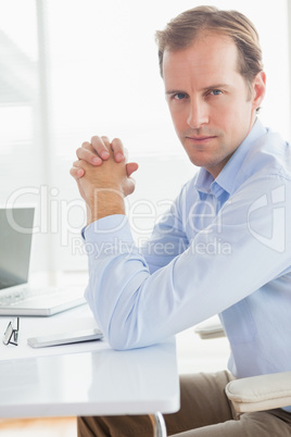 Serious businessman looking at camera at desk Serious businessman looking at camera at desk
