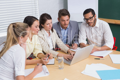 Focused business team having a meeting using laptop