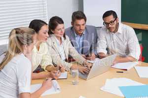 Focused business team having a meeting using laptop