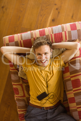 Young man listening to music on his couch