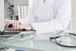 Doctor typing on her laptop