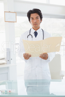 Serious looking doctor with medical files