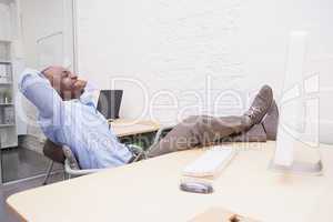 Businessman relaxing at desk and smiling