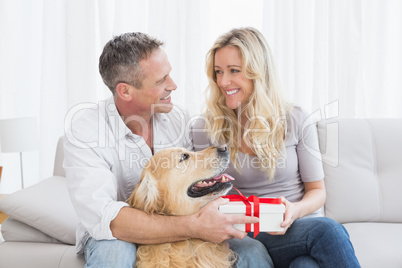 Cute couple sitting holding a gift