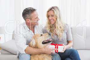 Cute couple sitting holding a gift